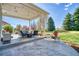 Covered patio with outdoor furniture, string lights, lush lawn, and beautiful backyard at 6800 Saddleback Ave, Firestone, CO 80504