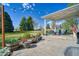 Covered patio with outdoor furniture, string lights, manicured landscaping, and grass yard at 6800 Saddleback Ave, Firestone, CO 80504
