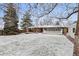 Backyard featuring a covered patio, a fire pit, and a charming white picket fence at 977 S Reed St, Lakewood, CO 80226