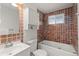 Full bathroom with tiled walls, a bathtub, vanity, and a window, offering a clean and functional space at 977 S Reed St, Lakewood, CO 80226