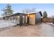 Charming home featuring a brick accent wall, stylish black siding, and a lovely white picket fence at 977 S Reed St, Lakewood, CO 80226