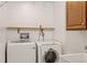 Bright laundry room with modern washer and dryer, plus storage cabinet and utility sink at 977 S Reed St, Lakewood, CO 80226