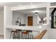 Bar area in a modern, open-plan living room with stylish stools, sleek countertop, and bright, inviting lighting at 977 S Reed St, Lakewood, CO 80226