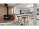 Open-concept living area with a wood-burning stove, a breakfast bar and stylish stools at 977 S Reed St, Lakewood, CO 80226