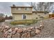 Backyard view of home with unique rock landscaping and a small grass area at 9014 W Harvard Dr, Lakewood, CO 80227