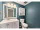 Cozy bathroom featuring a vanity, toilet, cabinet, and a large framed mirror at 1273 S Crystal Way, Aurora, CO 80012