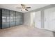 Neutral bedroom features a ceiling fan, closet with mirrored doors, and two entry doors at 1273 S Crystal Way, Aurora, CO 80012