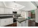 Bright kitchen with white cabinetry, stainless steel appliances, and an island with dark countertop at 1273 S Crystal Way, Aurora, CO 80012