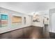 Bright and spacious living room with dark wood floors, fresh paint, large windows, and a pass-through to the kitchen at 1273 S Crystal Way, Aurora, CO 80012