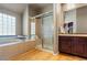 Relaxing bathroom with a soaking tub, walk-in shower, and vanity with wooden cabinets, perfect for unwinding at 474 Silbrico Way, Castle Rock, CO 80108