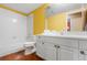 Bright bathroom with white tile, a wooden floor, and a well-lit vanity, offering a clean and functional space at 474 Silbrico Way, Castle Rock, CO 80108