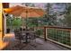Twilight on a well-appointed deck: umbrella-shaded table, chairs, flowers, and serene wooded backdrop at 474 Silbrico Way, Castle Rock, CO 80108