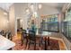 Dining room with rustic chandelier, large window with shutters, and a patterned rug beneath the table at 474 Silbrico Way, Castle Rock, CO 80108