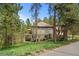 View of the house surrounded by lush trees, manicured lawn and shrubs, accentuating its charm and curb appeal at 474 Silbrico Way, Castle Rock, CO 80108