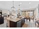 Open-concept kitchen with a large island, bar seating, and seamless flow into the dining and living areas at 2637 Gray Wolf Pl, Castle Rock, CO 80104