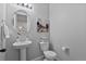 This powder room features a pedestal sink, decorative mirror, and stylish toilet for guests at 2637 Gray Wolf Pl, Castle Rock, CO 80104