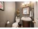 Charming powder room featuring a vintage-style sink, dark wall paint, and decorative fixtures at 8300 Fairmount Dr # Qq102, Denver, CO 80247