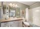 Well lit bathroom featuring tile countertops, decorative painting, mirror, and bath with shower at 8300 Fairmount Dr # Qq102, Denver, CO 80247