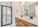 Contemporary bathroom with double vanity, sleek fixtures, and glass-enclosed shower, blending style and functionality at 888 S Valentia St # 103, Denver, CO 80247