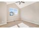 Bright bedroom with neutral carpet and vaulted ceiling, offering a peaceful retreat with a large picture window at 888 S Valentia St # 103, Denver, CO 80247
