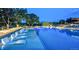 Community pool with lounge chairs in the water at twilight at 888 S Valentia St # 103, Denver, CO 80247