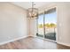 Bright dining room featuring wood floors, modern light fixture, and sliding glass doors to outdoor deck at 888 S Valentia St # 103, Denver, CO 80247