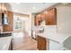 Modern kitchen featuring wood cabinets, stainless steel appliances, light countertops and seamless access to the living area at 888 S Valentia St # 103, Denver, CO 80247