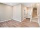 Bright living room with wood-look floors, neutral paint, base trim, and access to the upper floor at 888 S Valentia St # 103, Denver, CO 80247
