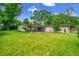 Lush backyard with mature trees and a patio area, providing a serene and private outdoor space at 3736 S Hibiscus Way, Denver, CO 80237
