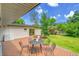 Lovely backyard patio with outdoor dining set, surrounded by lush green grass and mature trees at 3736 S Hibiscus Way, Denver, CO 80237