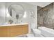 Stylish bathroom with a modern vanity, round mirror, and tiled shower/tub combo at 3736 S Hibiscus Way, Denver, CO 80237