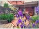 A charming brick patio surrounded by vibrant flowers and lush greenery offers a serene outdoor space at 4416 Brentwood St, Wheat Ridge, CO 80033