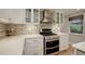 Stylish kitchen featuring a stainless steel range and oven surrounded by white cabinetry at 4416 Brentwood St, Wheat Ridge, CO 80033