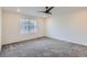 A spacious bedroom with carpet flooring, ceiling fan, and natural light through a large window at 645 Flintwood Pl, Lafayette, CO 80026