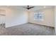 An empty bedroom with carpet flooring, ceiling fan, and natural light through a large window at 645 Flintwood Pl, Lafayette, CO 80026