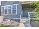 Blue two-story home with covered front porch, small yard, and exterior basement access at 645 Flintwood Pl, Lafayette, CO 80026