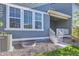 Blue two-story home with covered front porch, small yard, and exterior basement access at 645 Flintwood Pl, Lafayette, CO 80026