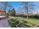 Landscaped backyard with lush green grass, stone walkway, garden beds and trees at 5285 E Iliff Ave, Denver, CO 80222