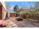 Backyard patio with brick accents, lush lawn and mature tree providing shade at 5285 E Iliff Ave, Denver, CO 80222