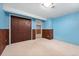 Finished basement area with neutral carpet, knotty pine trim and large closet doors at 5285 E Iliff Ave, Denver, CO 80222