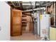 Unfinished basement with water heater, shelves, open louvered door and exposed ductwork at 5285 E Iliff Ave, Denver, CO 80222