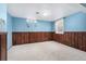 Finished basement area with neutral carpet, knotty pine trim, two small windows and nautical themed decor at 5285 E Iliff Ave, Denver, CO 80222