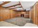 Rustic basement featuring knotty pine paneling, wood beams, a fireplace and decorative carpet at 5285 E Iliff Ave, Denver, CO 80222