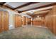 Finished basement with knotty pine walls, beamed ceiling and access to a wet bar at 5285 E Iliff Ave, Denver, CO 80222