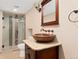 Cozy bathroom featuring unique vessel sink, granite countertop, and a glass enclosed shower with tile surround at 5285 E Iliff Ave, Denver, CO 80222