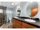 This bathroom features double sinks with granite countertops, a glass enclosed shower, and a comfort height toilet at 5285 E Iliff Ave, Denver, CO 80222