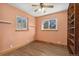 Bright bedroom with wood floors, light walls, built-in shelving, and two windows providing ample sunlight at 5285 E Iliff Ave, Denver, CO 80222