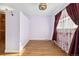 A bright bedroom featuring hardwood floors and a large window with decorative curtains at 5285 E Iliff Ave, Denver, CO 80222