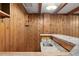 Wet bar with knotty pine walls, granite countertop, stainless steel sink and decorative lighting at 5285 E Iliff Ave, Denver, CO 80222