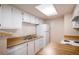 Functional kitchen with white cabinetry, wood-style countertops, and a suite of appliances at 13241 E Asbury Dr # 203, Aurora, CO 80014